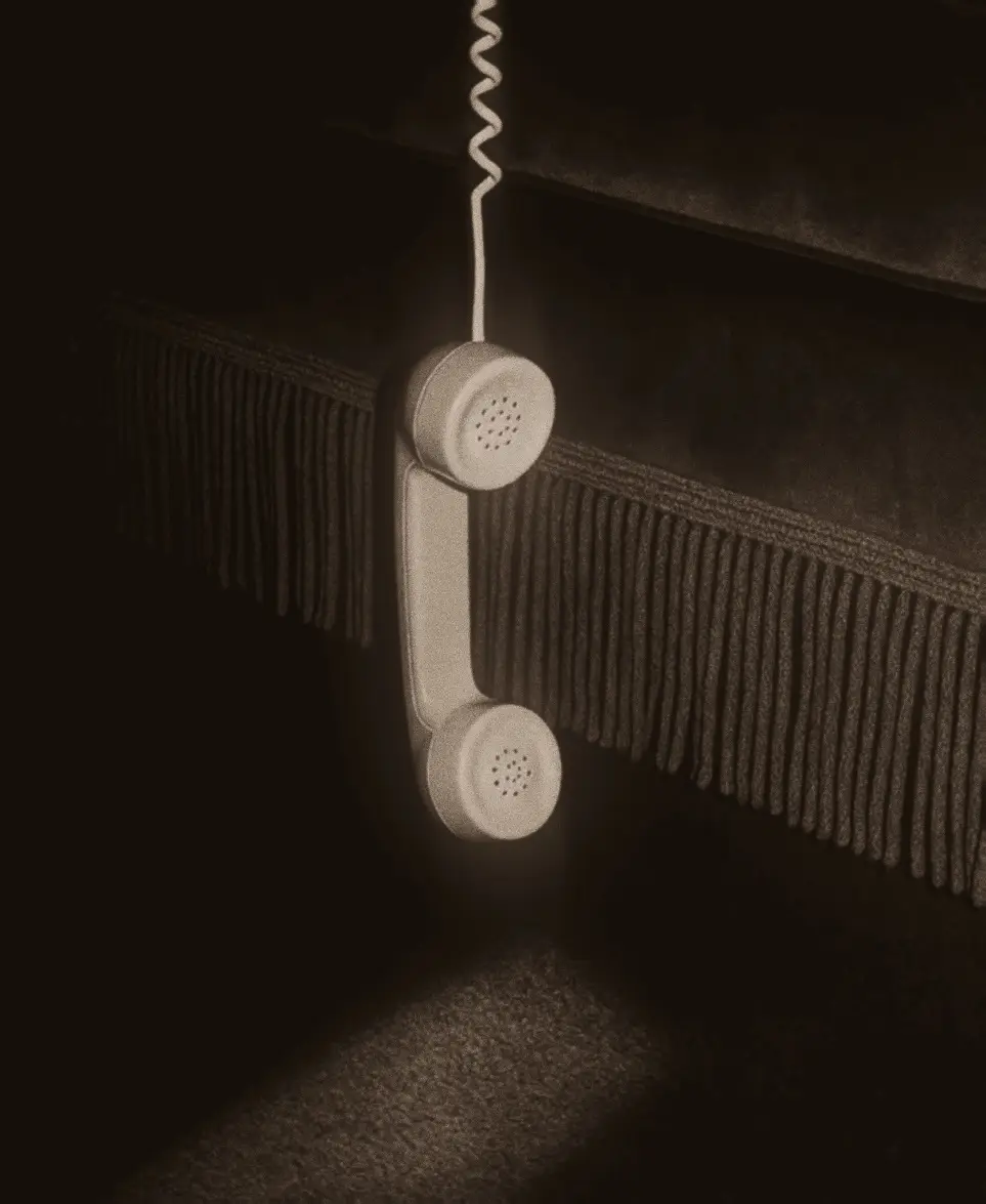 A retro telephone handset hanging by its cord